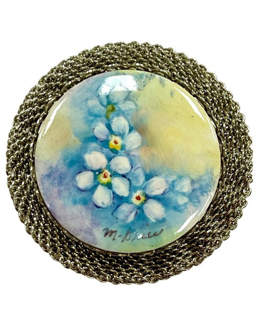 Silver Blossom Ceramic Brooch: Silver Blossom Ceramic Brooch Evoke elegance with our Silver Blossom Ceramic Brooch, where hand-painted flowers on fine ceramic meet intricate silver detailing. This wearable work of art not only
