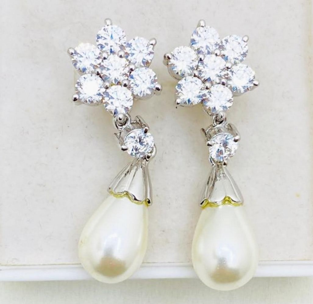 Zirconia Flower Pearl Drop Earrings: Zirconia Flower Pearl Drop Earrings Pearls are a timeless accessory perfect to add elegance to any outfit. View Photos For Further Details.