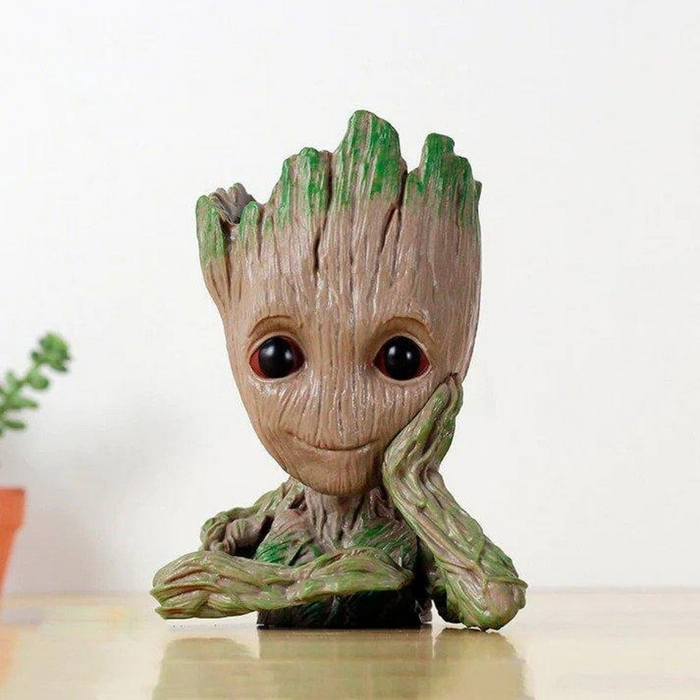 5.5" Blooming Baby Groot Planter Pot: 5.5" Blooming Baby Groot Planter Pot Introducing our 5.5" Blooming Baby Groot Planter Pot, a charming addition to your space that seamlessly blends pop culture and greenery. This adorable