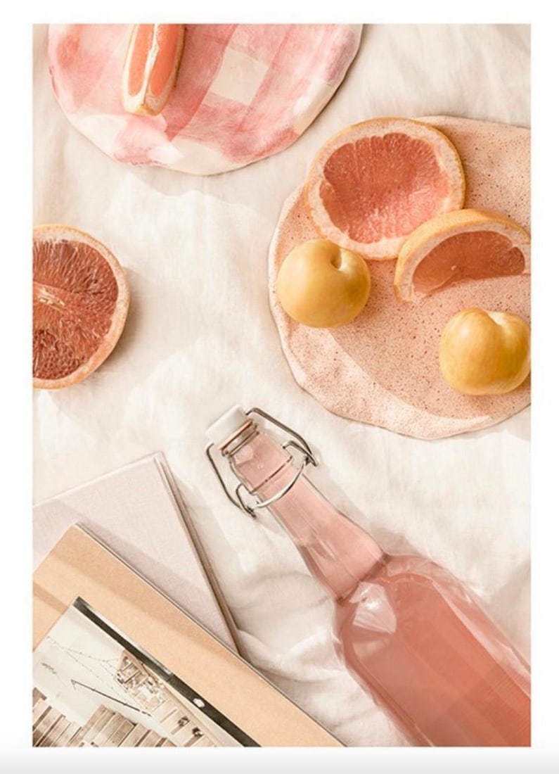 Pink Picnic Poster: Pink Picnic Poster Photography of a picnic with pink lemonade, grapefruit and more accessories laying on a light beige blanket. Colourful and fun poster with a summery vibe. The poster has a white