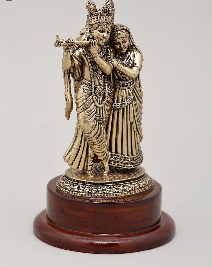 5" Divine Radha and Krishna on Wooden Base: 5" Divine Radha and Krishna on Wooden Base This 5" brass sculpture beautifully depicts Radha and Krishna, the eternal divine couple, capturing their loving and spiritual union. Krishna is sho
