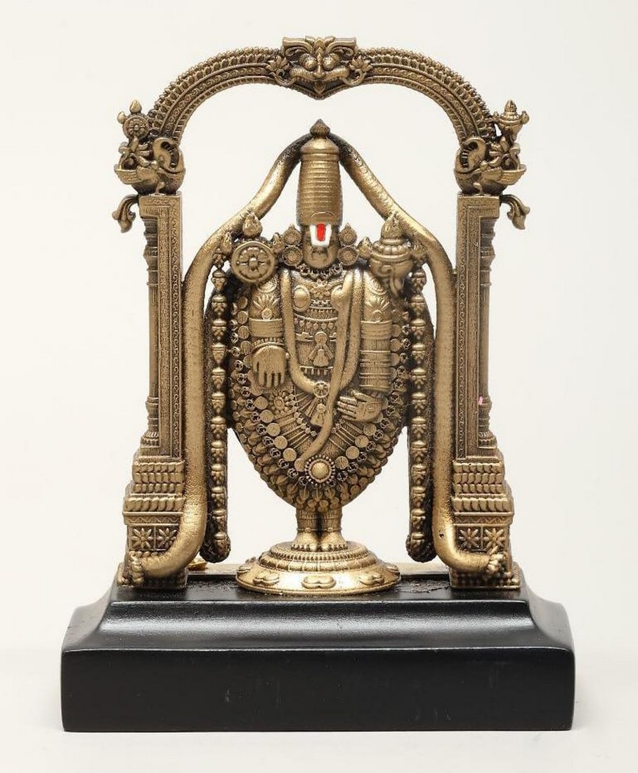 Standing Tirupati Balaji Mini Brass Statue with Kirtimukha Arch: Standing Tirupati Balaji Mini Brass Statue with Kirtimukha Arch This handcrafted brass statue depicts Tirupati Balaji, a revered incarnation of Lord Vishnu, standing beneath a Kirtimukha arch, a symb