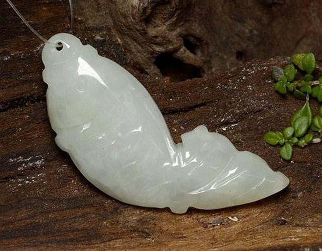 28.92ct Natural Grayish White Jadeite, Fancy, Translucent: 28.92ct Natural Grayish White Jadeite, Fancy, Translucent Natural jadeite gemstone weighing 28.92 carats, carved in the shape of a fish with a drilled hole (0.65 mm diameter) for stringing or jewelry