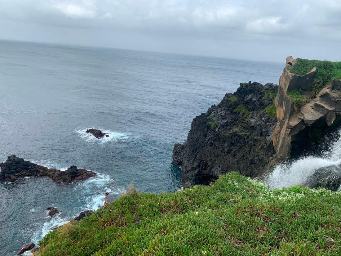 Cliffside Serenity: Cliffside Serenity Experience the beauty of the coast captured in this exclusive hand-painted canvas offer. The photograph showcases a breathtaking view from a cliffside overlooking the vast ocean, w