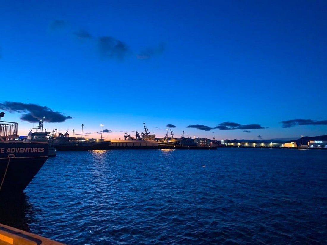 Harbor Dusk: Harbor Dusk Bring the serene beauty of an Icelandic harbor at sunset into your home with this exclusive hand-painted canvas opportunity. The photograph captures deep blue waters and sky, with a