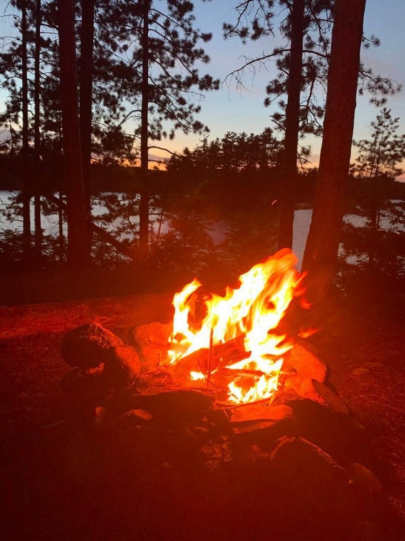 Campfire Glow: Campfire Glow Experience the cozy charm of an evening in the wilderness with this exclusive hand-painted canvas opportunity. The photograph captures a fire burning warmly in a campsite firepit,