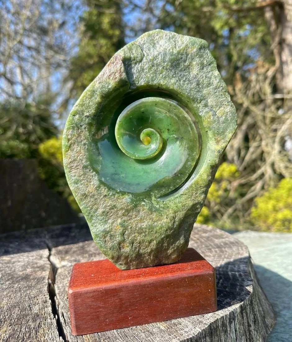 Koru Carving – Canadian Nephrite Jade: Koru Carving – Canadian Nephrite Jade Beautifully carved Koru made from Canadian nephrite jade, symbolizing new life, growth, strength, and peace. The carving showcases the natural beauty and variat