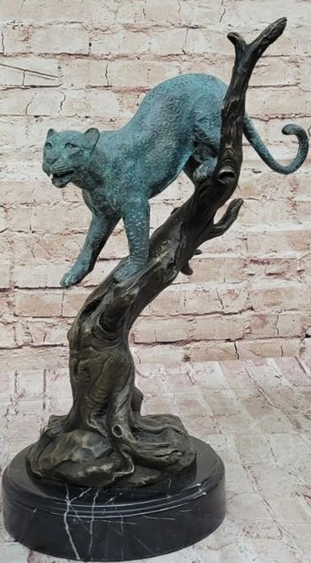 Leopard in Tree Bronze Sculpture: Leopard in Tree Bronze Sculpture This striking bronze sculpture captures a graceful leopard as it carefully descends a tree, its head held high in a curious and alert pose. The tree is rendered in a