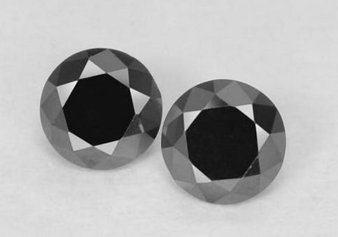 Set of Two Black Diamond-Cut Gemstones: Set of Two Black Diamond-Cut Gemstones This elegant pair of loose gemstones features expertly faceted black diamonds in a classic diamond-cut shape. Their deep, opaque luster and sharp facets