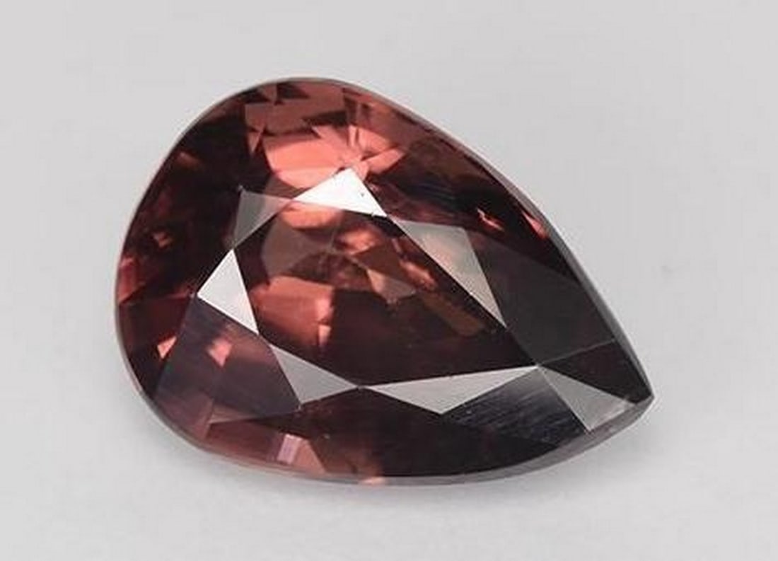 Crimson Ember Wine Red Pear Faceted Zircon: Crimson Ember Wine Red Pear Faceted Zircon Rich and radiant, this wine red Zircon gemstone glows with deep, smoldering elegance. Cut in a graceful pear facet, it captures and reflects light with a