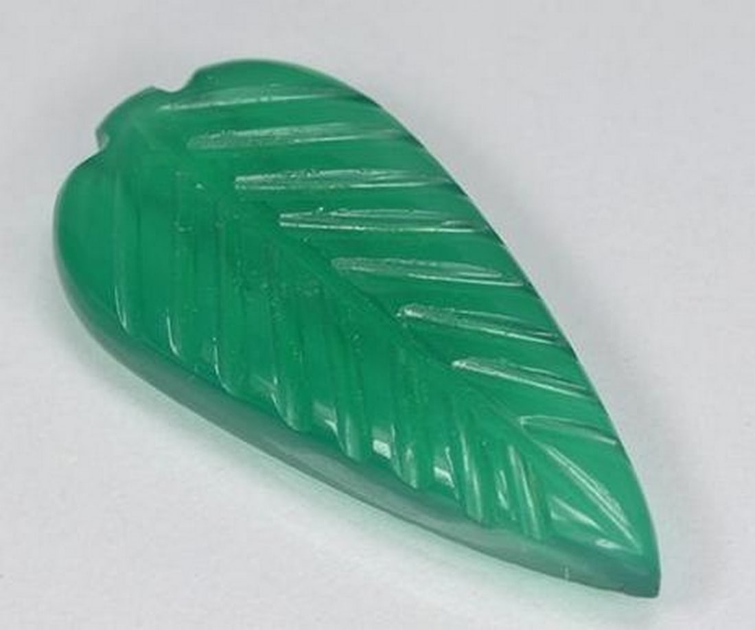 Warm Green Agate Carved Leaf Gemstone: Warm Green Agate Carved Leaf Gemstone This imaginative loose gemstone is carved from warm green agate into a stylized fantasy leaf, blending natural elegance with artistic flair. Flowing curves and i