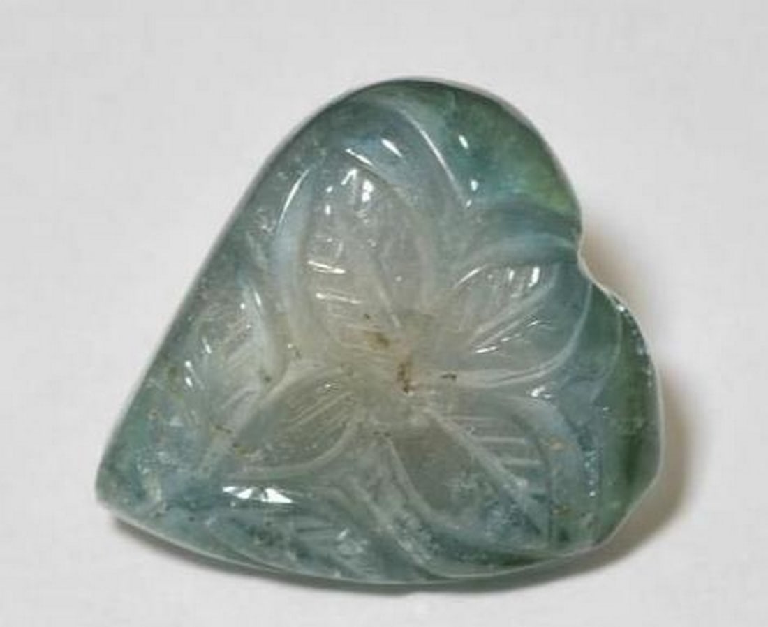 Greenish Blue Tourmaline Carved Flower Gemstone: Greenish Blue Tourmaline Carved Flower Gemstone Delicately carved from lustrous greenish blue tourmaline, this loose gemstone captures the graceful beauty of a blooming flower. The rich, oceanic hue