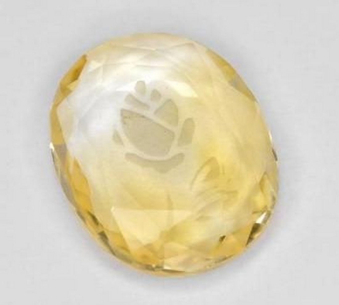 Bright Gold Citrine Oval Gemstone with Etched Flower Detail: Bright Gold Citrine Oval Gemstone with Etched Flower Detail Radiating warmth and brilliance, this loose citrine gemstone is carved into an elegant oval and features a delicate flower etched into