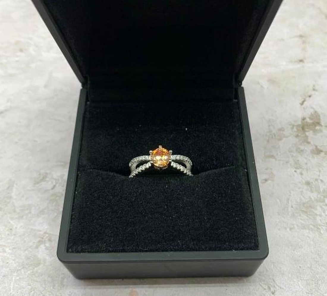 Radiant Orange Sapphire & Topaz Ring in Sterling Silver: Radiant Orange Sapphire & Topaz Ring in Sterling Silver Bold and radiant, this 925 sterling silver ring features a striking round-cut orange gemstone as its dazzling centerpiece. Framing the vivi