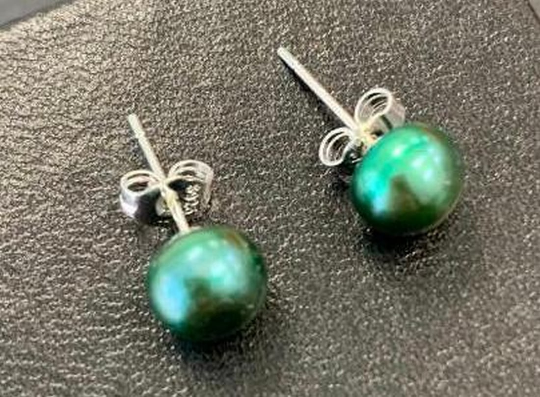 Green Pearl Stud Earrings: Green Pearl Stud Earrings Add a touch of timeless elegance to your look with these stunning earrings, set in sterling silver. Each earring features a green pearl. The minimalist sterling silver