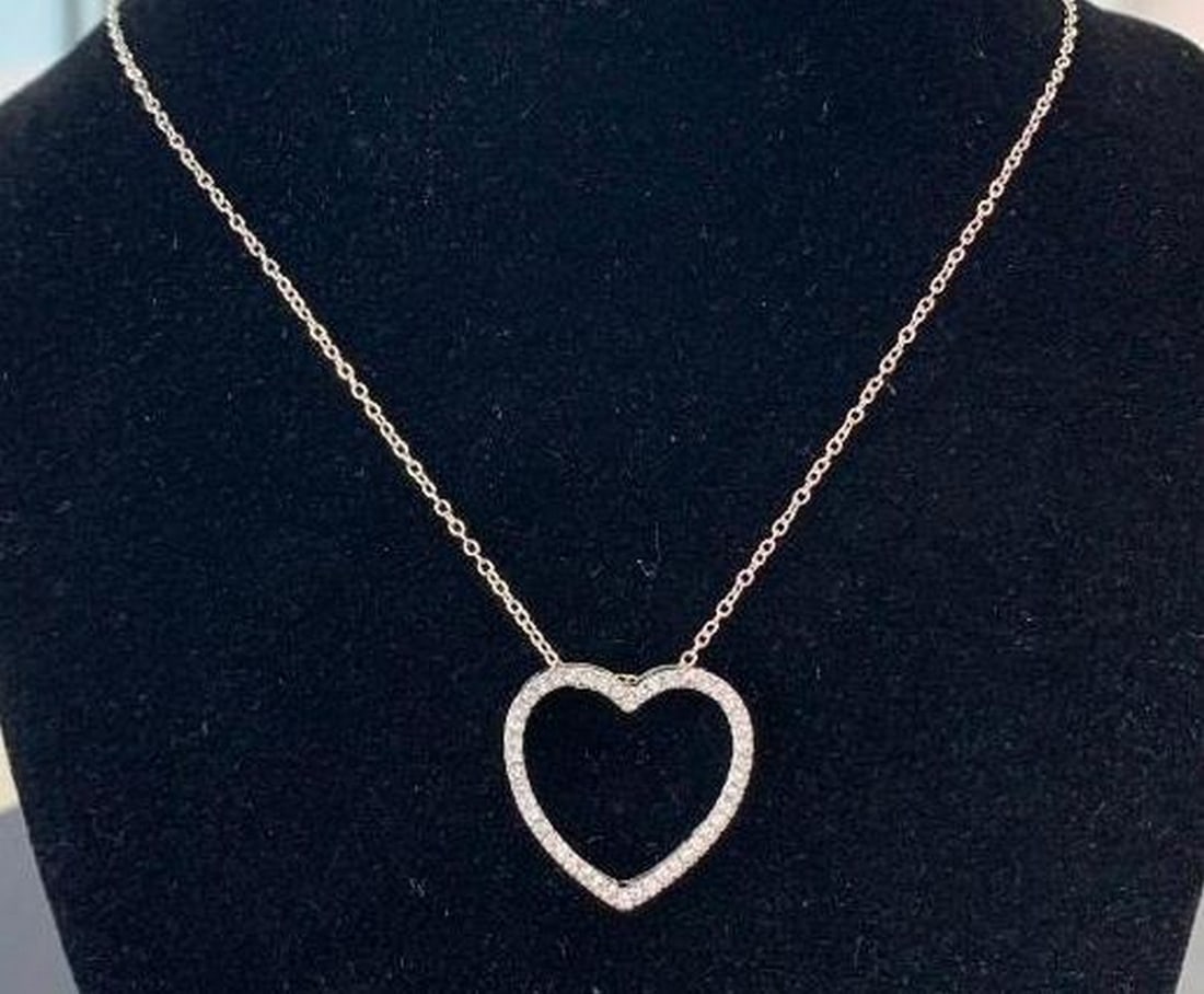 Heart Pendant Necklace: Heart Pendant Necklace Add a touch of sparkle to any outfit with this elegant silver-toned necklace featuring a heart-shaped pendant adorned with shimmering rhinestones. The sleek silver finish