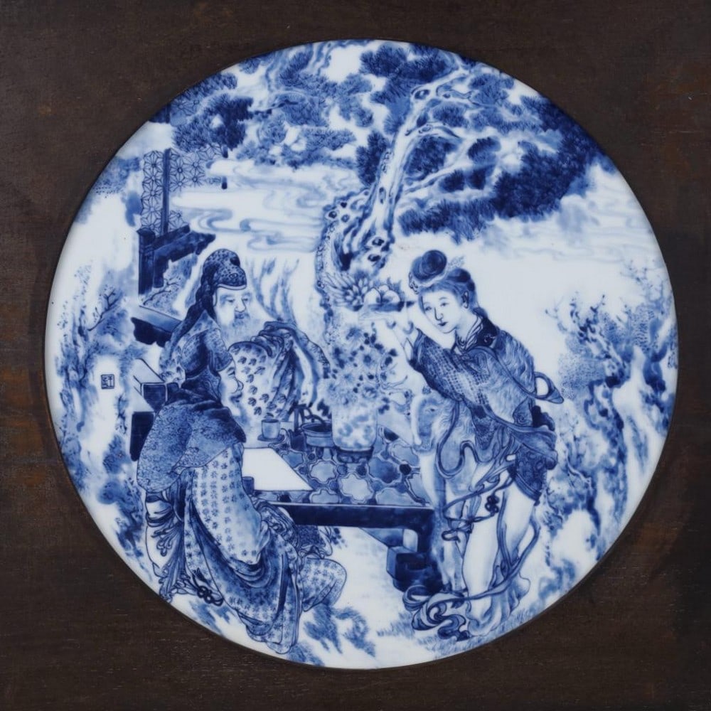 Blue and White Porcelain Plaque Outdoor Dining Scene: Blue and White Porcelain Plaque Outdoor Dining Scene This elegant blue and white porcelain plaque depicts a tranquil outdoor dining scene rendered in masterful brushwork. Two gentlemen in traditional