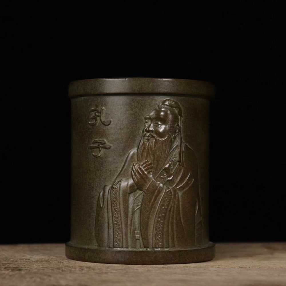 Bronze Confucius Pen Holder: Bronze Confucius Pen Holder This distinguished pen holder features a finely rendered image of Confucius, the great Chinese philosopher and teacher, symbolizing wisdom, learning, and moral