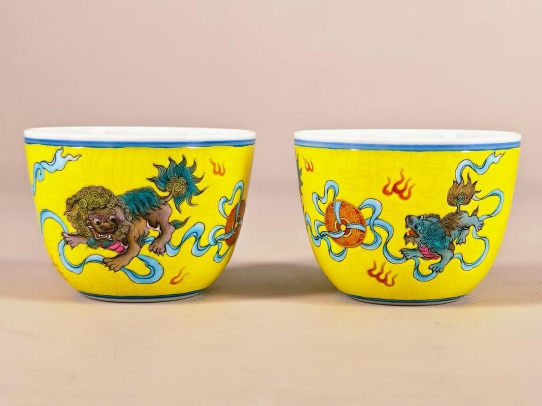 Bright Yellow Ground with Auspicious Lions Bowls: Bright Yellow Ground with Auspicious Lions Bowls This vibrant pair of enamel bowls feature dynamic depictions of auspicious lions set against a striking bright yellow background. The mythical lions,