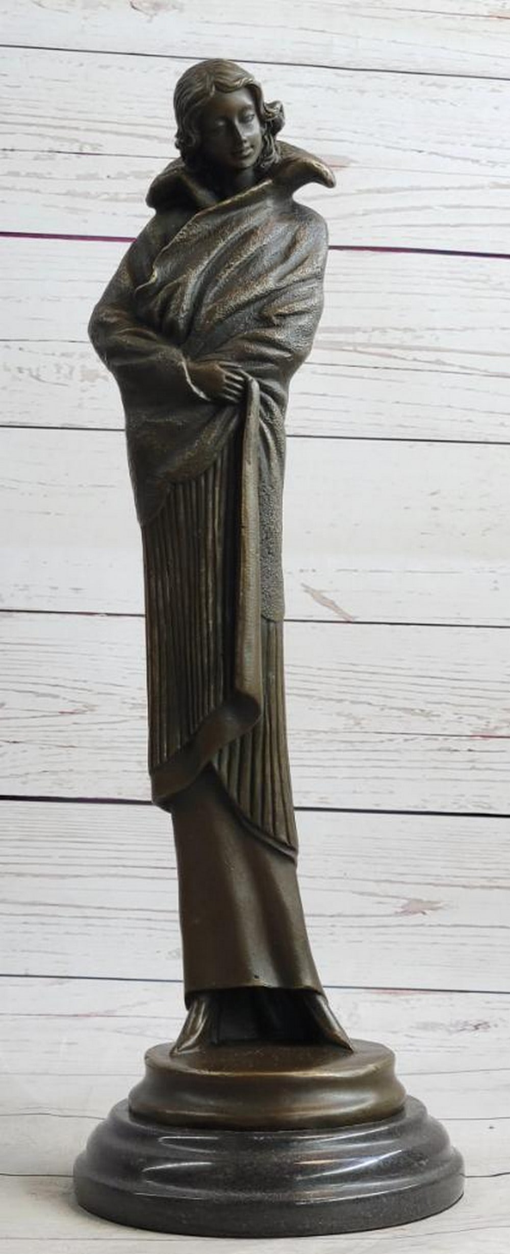 Art Deco Young Woman in Long Jacket Bronze Sculpture – 16" x 5": Art Deco Young Woman in Long Jacket Bronze Sculpture – 16" x 5" A graceful Art Deco bronze sculpture of a young woman wrapped in a long flowing jacket, her gaze turned downward as if strolli
