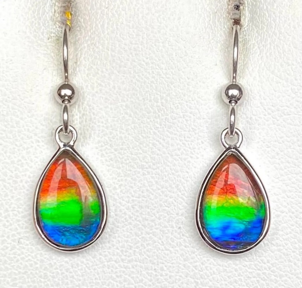 Multi-colour Teardrop Ammolite Earrings: Multi-colour Teardrop Ammolite Earrings These Ammolite earrings feature a graceful teardrop shape with tricolor gemstones measuring 12mm x 8mm as low-dome quartz-capped triplets. Set in sterling sil