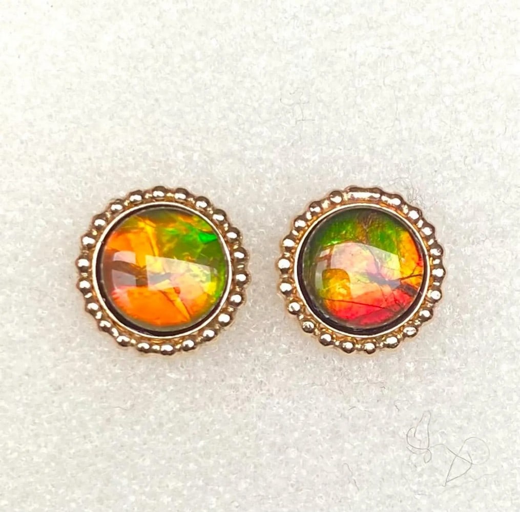 Ammolite Stud Earrings: Ammolite Stud Earrings This pair of Ammolite stud earrings features 8mm triplet gemstones that are bold, flashy, and shift to green at extreme angles, as seen in the photo. Set in durable gold-fille