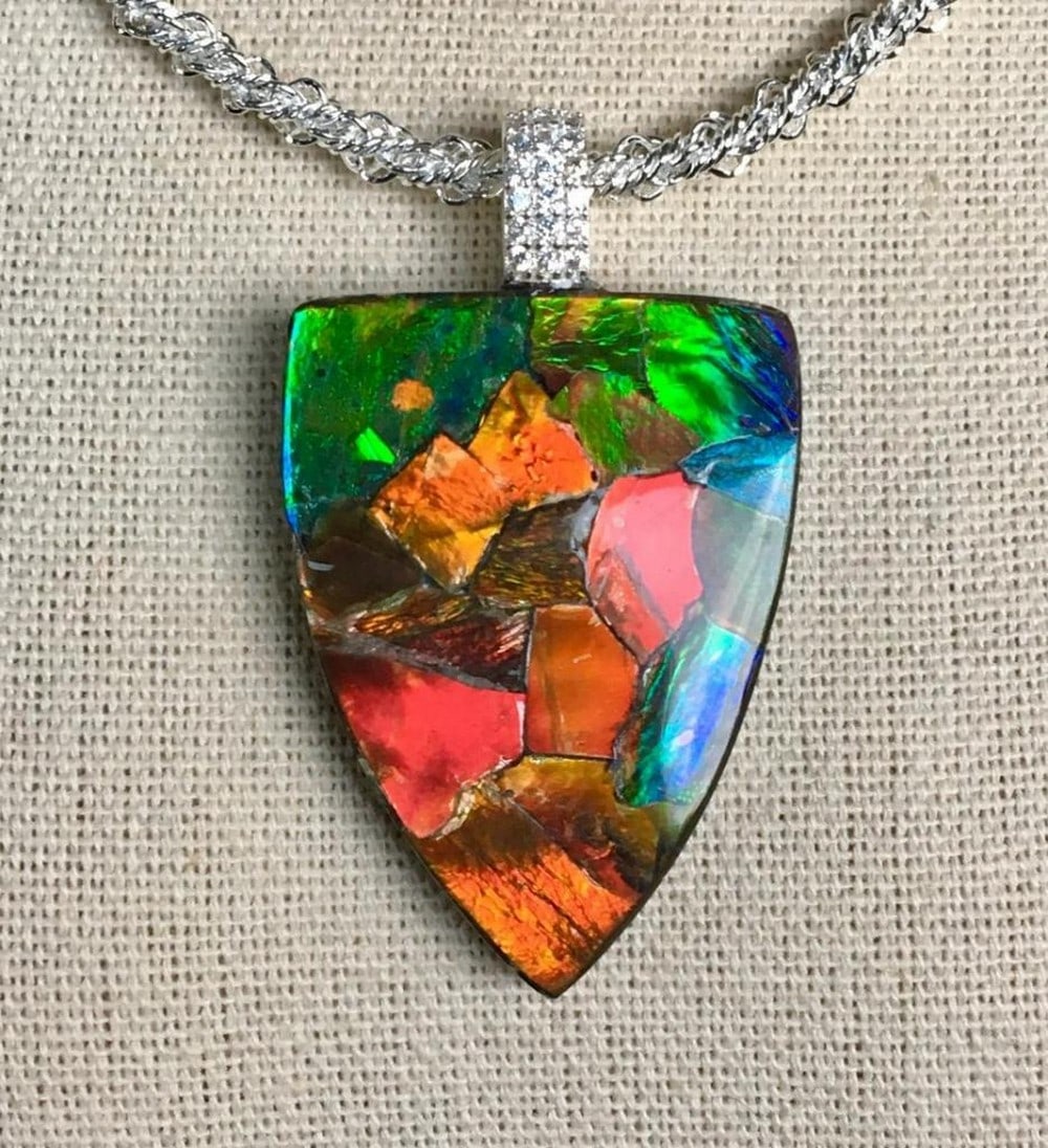 Grand Mosaic Ammolite Necklace Pendant: Grand Mosaic Ammolite Necklace Pendant This large-format ammolite pendant is crafted using leftover pieces from stone cutting, which are soaked in water to loosen the gem from the matrix. The delicate
