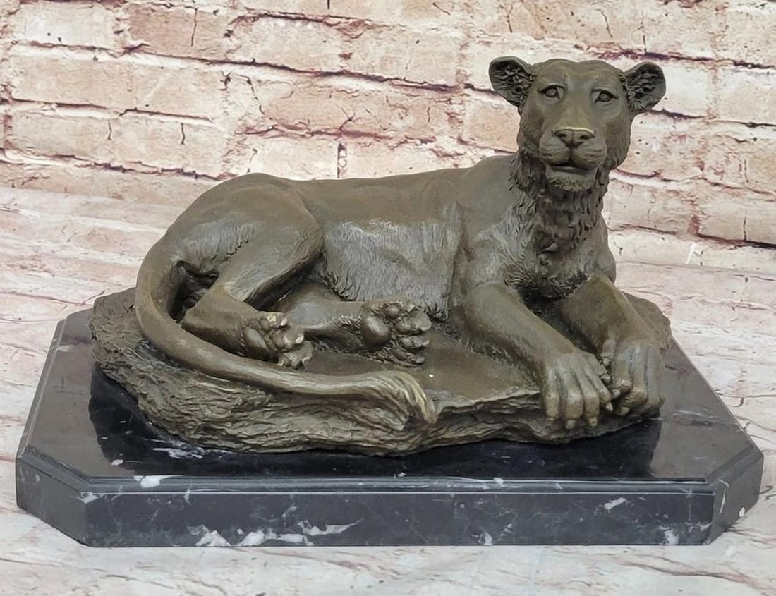 Lounging Lioness Inspired Bronze Statue - 8.5" x 13": Lounging Lioness Inspired Bronze Statue - 8.5" x 13" This exquisite bronze statue captures the serene elegance of a lioness in a relaxed, lounging pose. The detailed craftsmanship highlights