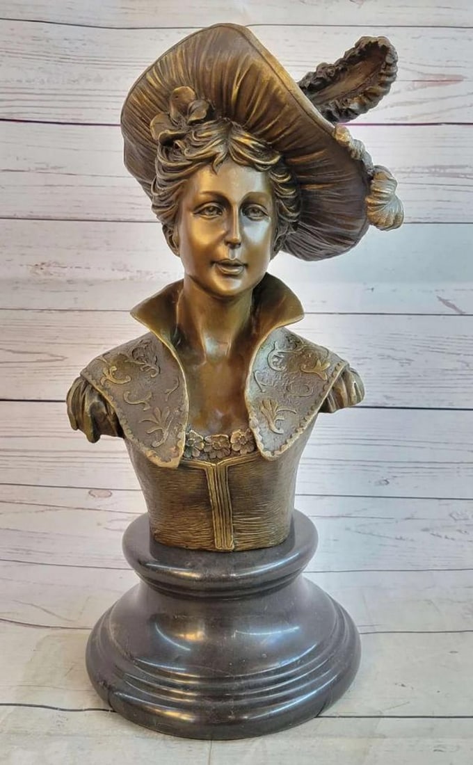 Bronze Bust Sculpture of a Victorian / Edwardian Woman On Marble Base: This is an amazing bust of a young woman from the 1900`s. She has a gorgeous hat while her hair is up in a unique style. She is wearing a corset that`s extremely tight and a high collar blazer