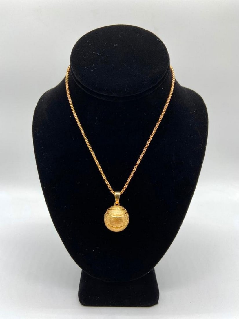 Basketball Locket: Basketball Locket This stylish gold-toned necklace features a unique basketball locket pendant that opens to hold a small photo or keepsake. Perfect for sports fans, athletes, or anyone who loves the