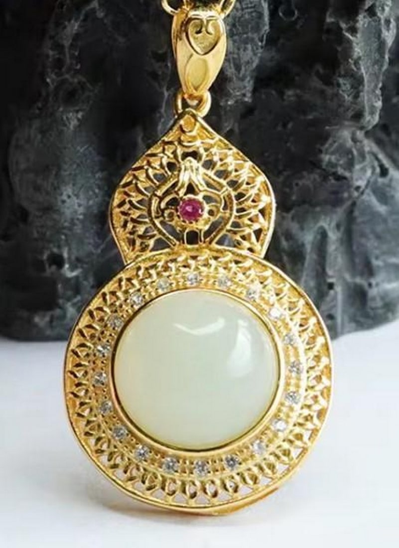 White Jade Pendant with Gold-Plated Sterling Silver: White Jade Pendant with Gold-Plated Sterling Silver A harmonious blend of elegance and artistry, this pendant features a smooth white jade stone framed in gold-plated sterling silver. Delicate white g