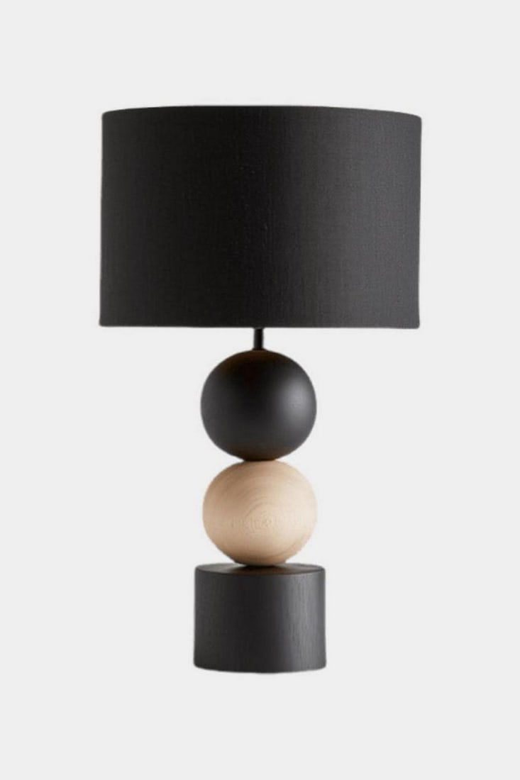 Contemporary Stacked Sphere Wood Lamp: Contemporary Stacked Sphere Wood Lamp This table lamp features a geometric stacked base composed of a matte black sphere, a natural wood sphere, and a cylindrical black base. A black cylindrical
