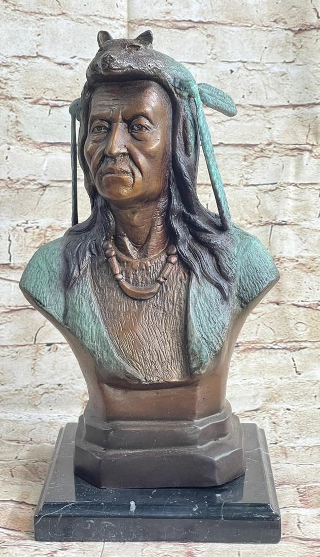 Native American Clothed In Wolf Headdress Bronze Bust Sculpture - 12lbs: A seasoned elder of his tribe, this Native American stands proudly as a symbol. This bust sculpture depicts a tribe leader, cloaked in a wool shawl and animal skin. The clothing of Native Americans wa