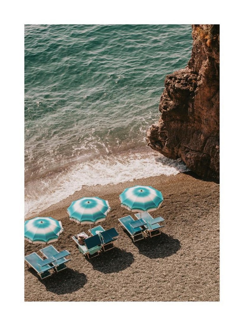 Beachside Parasols Poster: Beachside Parasols Poster A coastal print featuring three blue and white parasols set against a sunny beach. The simple composition and soft tones evoke a relaxed summer atmosphere. The design