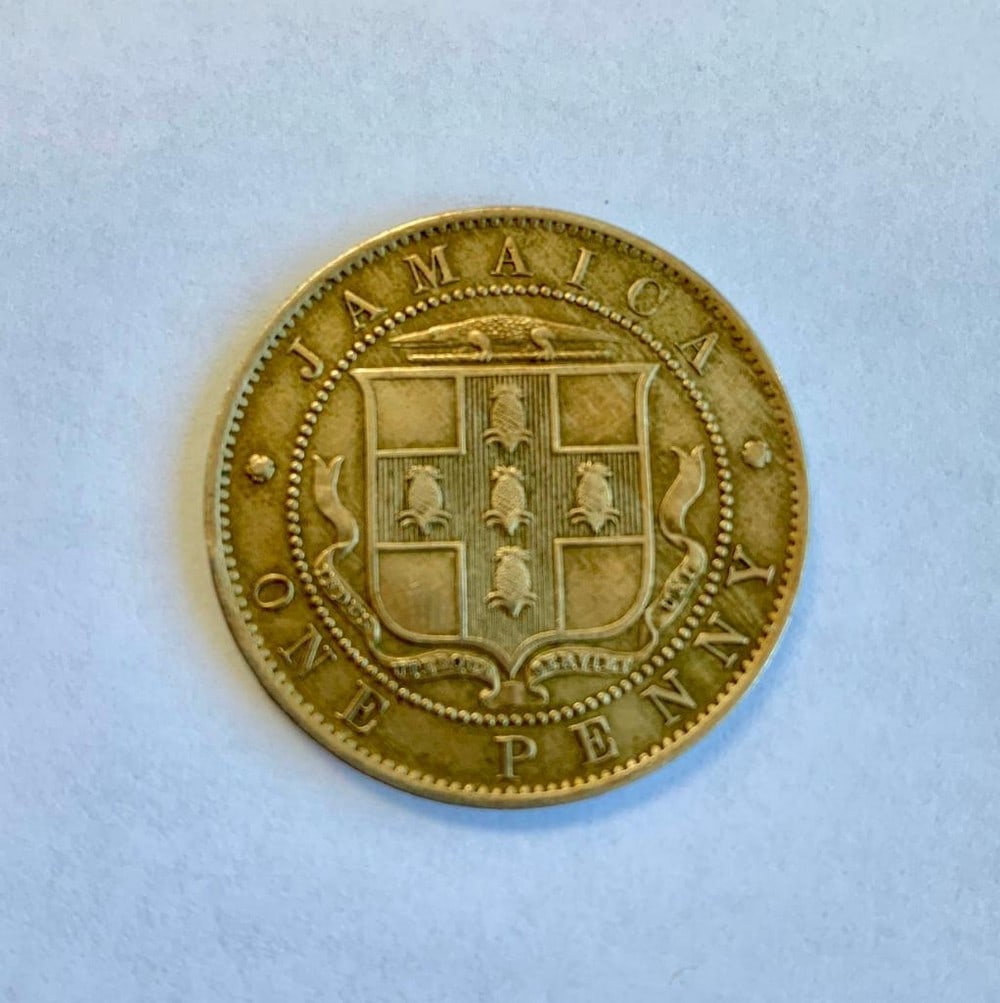 1909 Edward VII - Jamaica One Penny: Obverse Crowned portrait facing right within beaded circle. Lettering: EDWARD VII KING AND EMPEROR DES 1909 Engraver: George William de Saulles Reverse Arms with vertical shading within bea