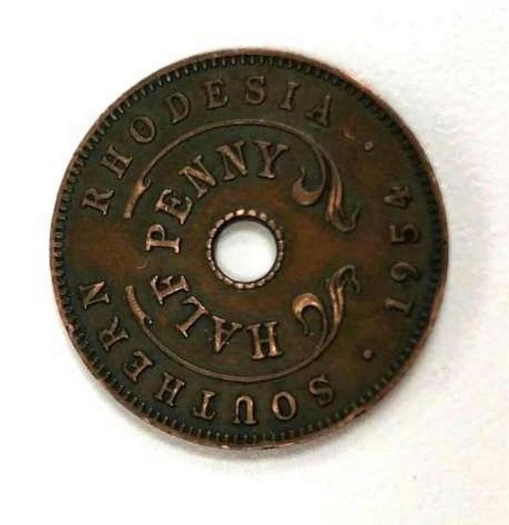 1954 Victoria II Southern Rhodesia Half Penny: Obverse Crowned flower center around hole, Writing around Lettering: QUEEN ELIZABETH THE SECOND Engraver: Derwent Wood Reverse Value written within sprigs, hole in center, name around outside, date be
