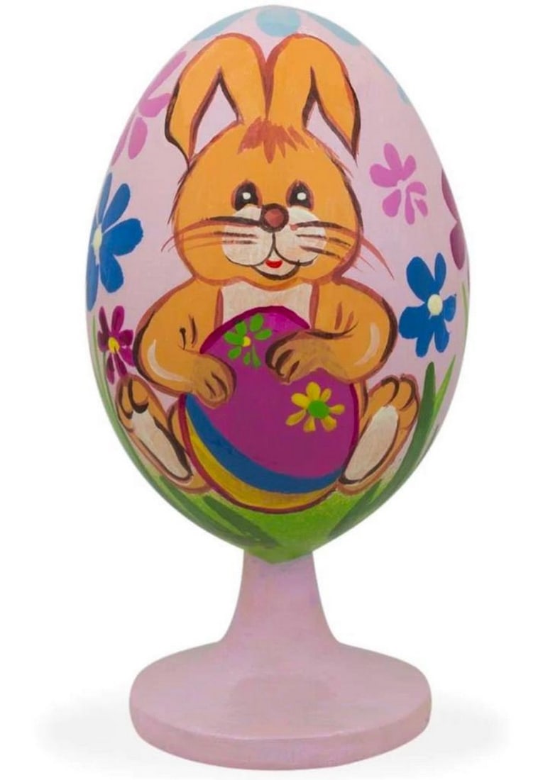 Lovable Bunny Decorating Easter Egg Wooden Figurine: Lovable Bunny Decorating Easter Egg Wooden Figurine. This adorable bunny decorating an Easter egg and colorful flowers are hand painted onto a wooden egg. This egg is 3.5 inches tall, hand