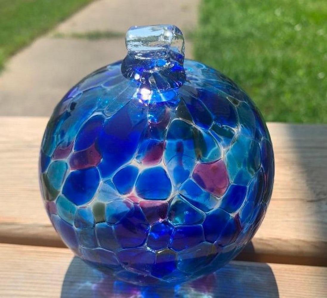 Handblown Glass Window Ornament in Ocean Blues: Handblown Glass Window Ornament in Ocean Blues Bring a touch of tranquility to your space with this 4" handblown glass window ornament, infused with the calming tones of ocean blues, accented by