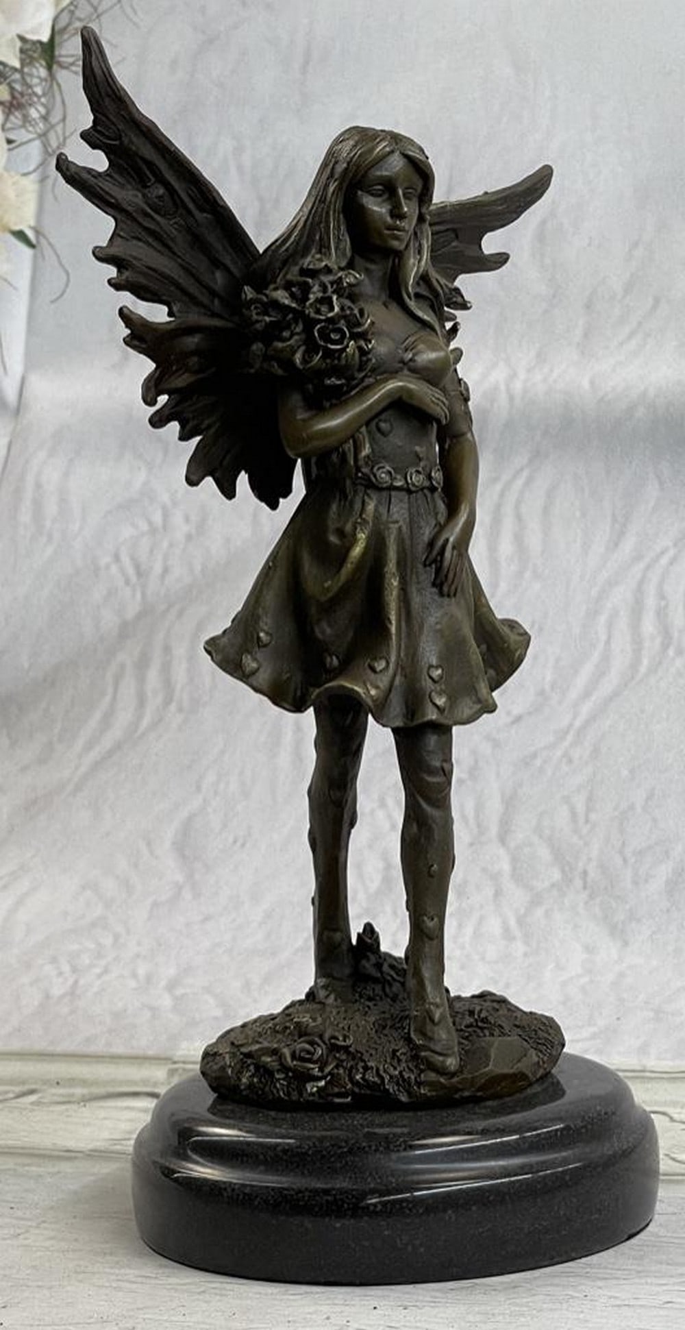 Fantasy Fairy Bronze Sculpture: Fantasy Fairy Bronze Sculpture This adorable angel of love will go perfectly in any room of your or a friends house. She stand gracefully holding a bouquet of roses on her right arm. Her