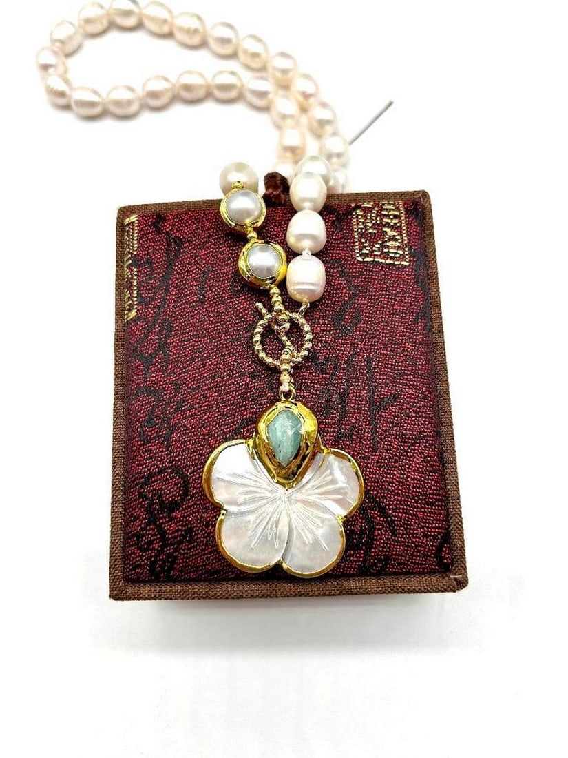 Baroque White Rice Pearl Necklace With Flower Shell Pendant: Baroque White Rice Pearl Necklace With Flower Shell Pendant This unique pearl necklace features a toggle clasp in the front of the necklace, as part of the design. The pendant and clasp are gold plat