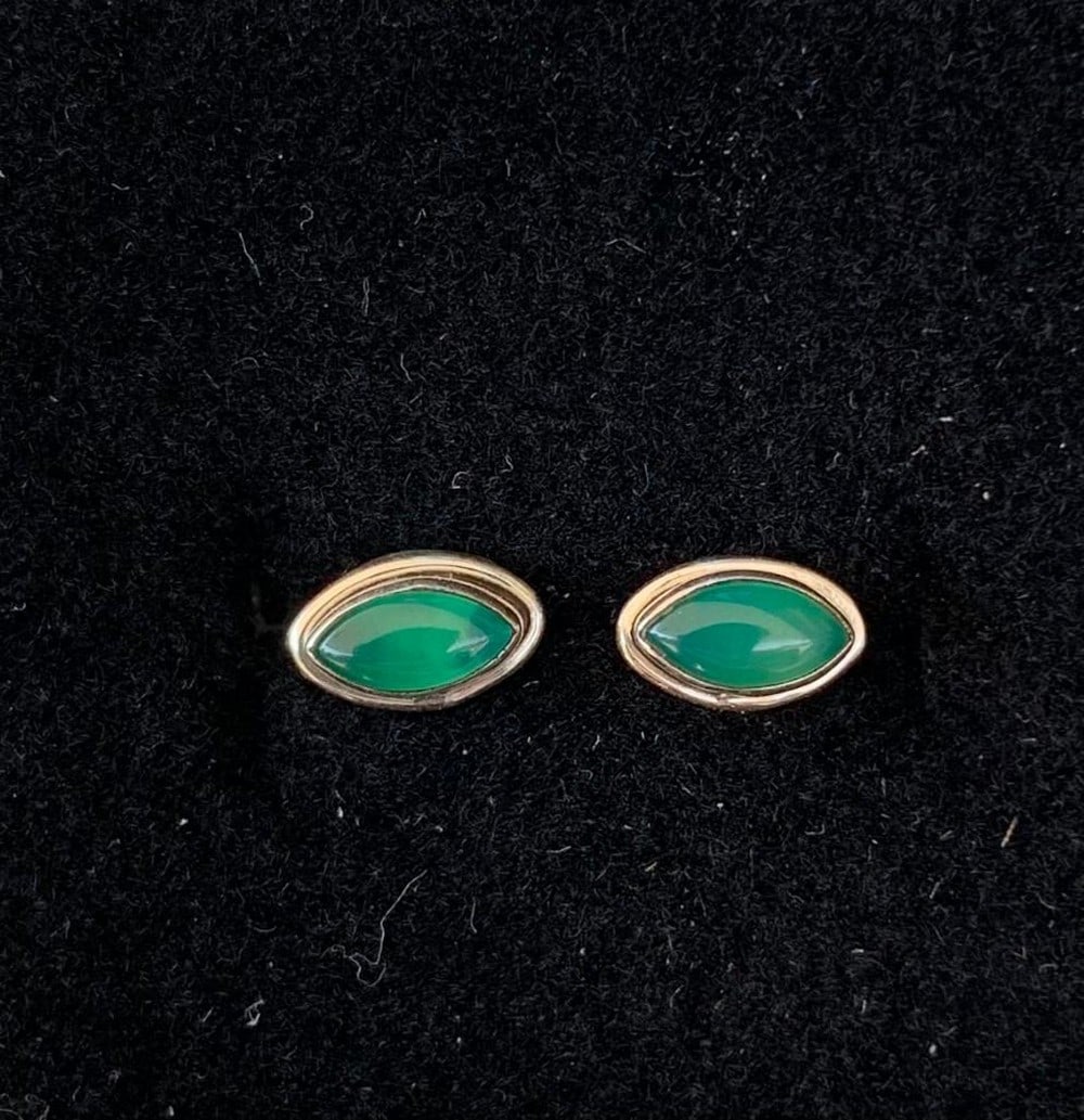 Mystic Cat-Eye Onyx Studs: Mystic Cat-Eye Onyx Studs These captivating cat-eye-shaped green onyx stud earrings feature a unique, elongated design that catches the light with every turn. The deep, rich green onyx is expertly
