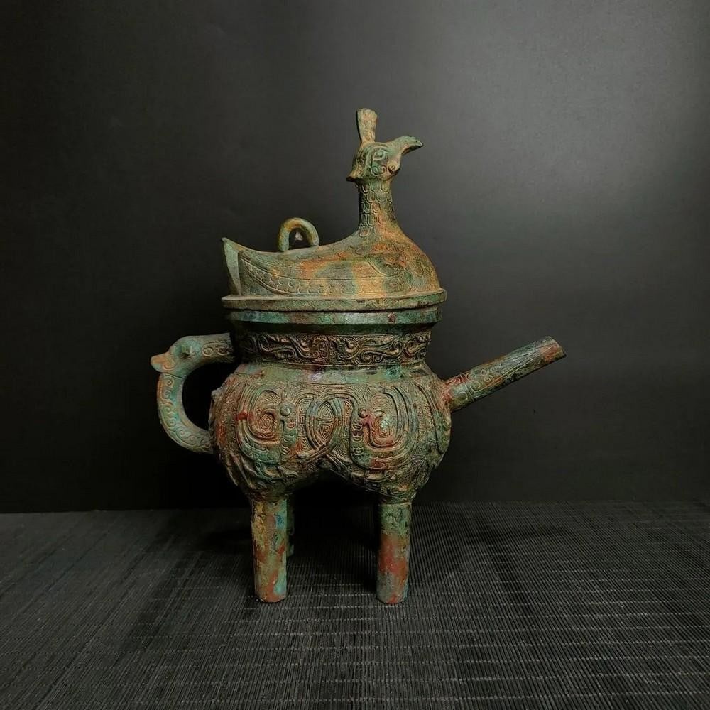 Antique Chinese Standing Bird Bronze Rice Pot: Antique Chinese Standing Bird Bronze Rice Pot This antique Chinese bronze rice pot features a unique standing bird design, symbolizing harmony and prosperity. The intricate detailing of the bird and