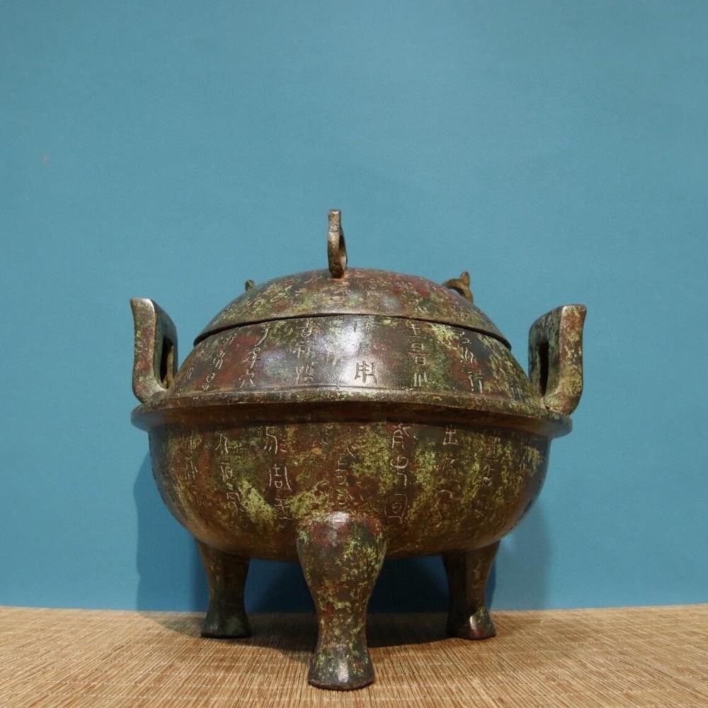 Bronze Inscribed Tripod with Lid: Bronze Inscribed Tripod with Lid This rare antique tripod statue, crafted from bronze, features intricate inscriptions and a fitted lid. Its pure hand-made design reflects the artistry of traditional