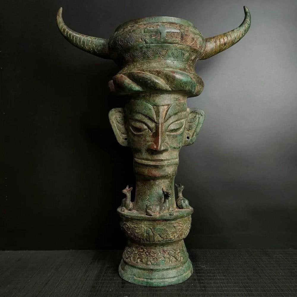 Antique Chinese Bronze Sanxingdui Tiangu Statue Ornament: Antique Chinese Bronze Sanxingdui Tiangu Statue Ornament This rare handcrafted bronze statue represents the ancient Sanxingdui Tiangu, a symbol of cultural heritage and divine power. The intricate de