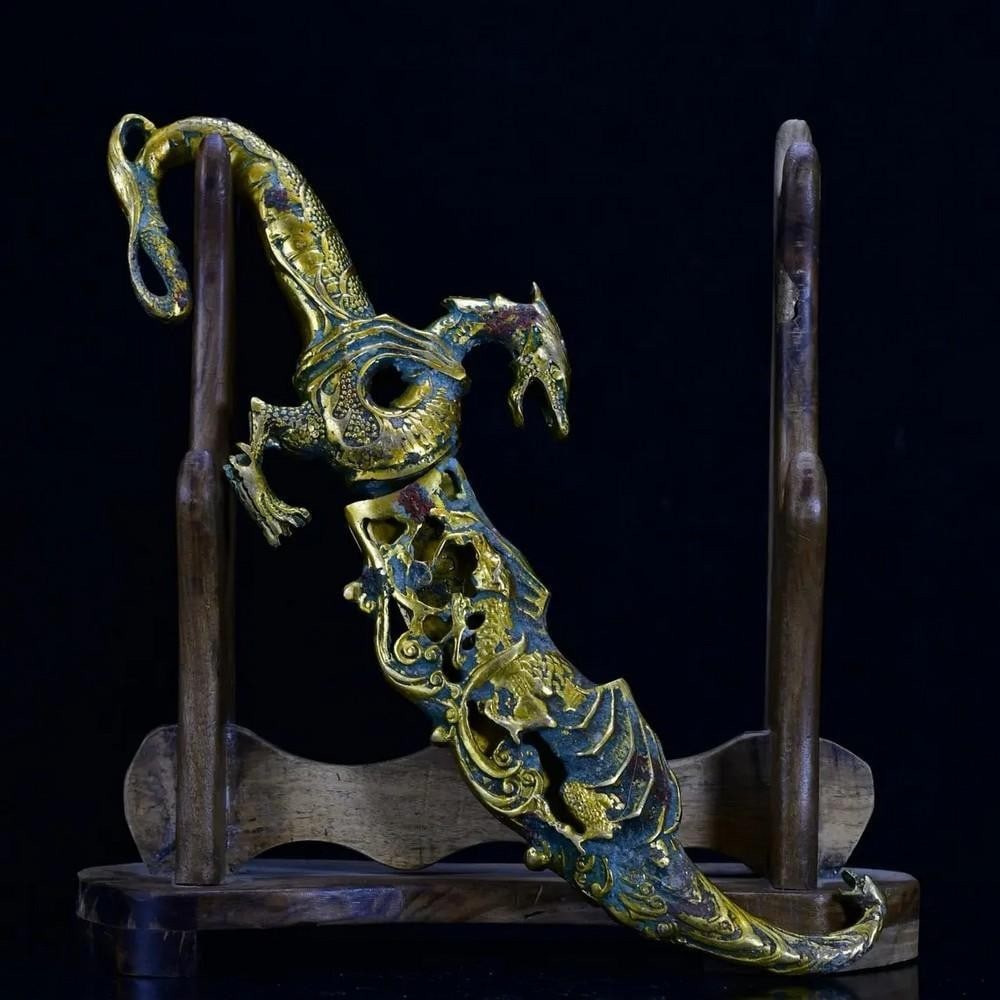 Antique Chinese Gilt Sheath Bronze Sword Ornament: Antique Chinese Gilt Sheath Bronze Sword Ornament This antique Chinese gilt sheath bronze sword ornament is a stunning blend of artistry and cultural heritage. The intricately designed bronze