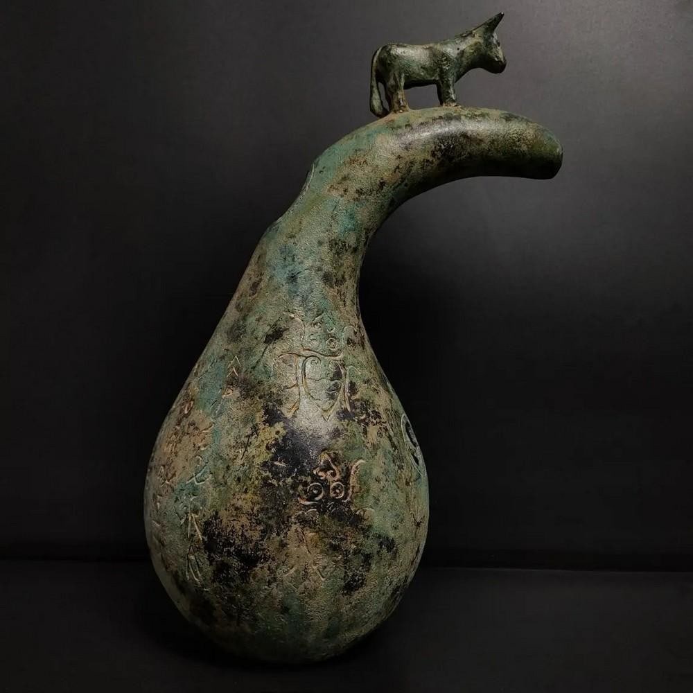 Antique Chinese Gourd Sheng Bronze Statue: Antique Chinese Gourd Sheng Bronze Statue This antique Chinese bronze statue depicts a gourd-shaped Sheng, a traditional Chinese wind instrument. The intricate detailing of the gourd’s surface