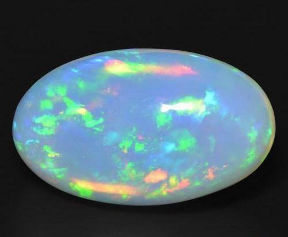 18.55 ct Oval Cabochon Rainbow Bluish-White Opal Gemstone: 18.55 ct Oval Cabochon Rainbow Bluish-White Opal Gemstone Introducing our Oval Cabochon Rainbow Bluish-White Opal Gemstone – a celestial dance of color encapsulated in a timeless elegance.