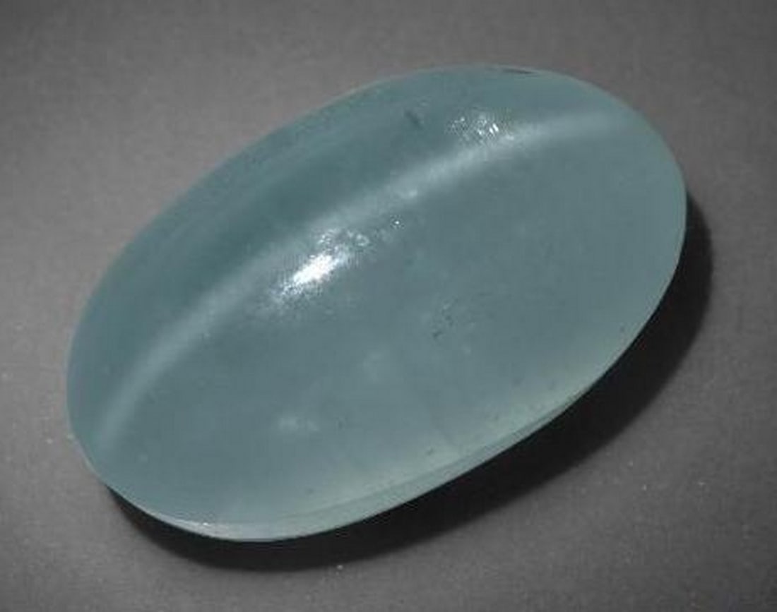 16ct Oval Cabochon Water Bluish Green Cat's Eye Aquamarine Gemstone: 16ct Oval Cabochon Water Bluish Green Cat's Eye Aquamarine Gemstone Discover the enchanting allure of our 16ct Oval Cabochon Water Bluish Green Cat's Eye Aquamarine Gemstone – a masterpiece