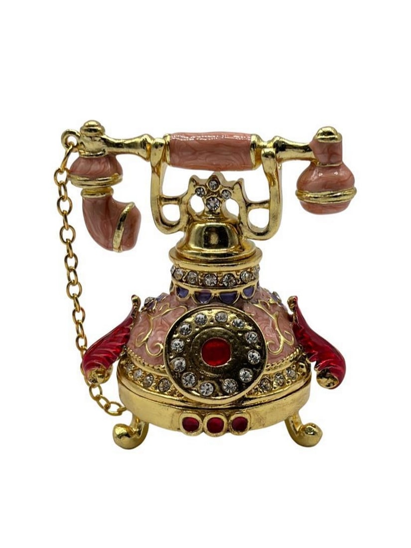 Pink Vintage Telephone Trinket Box: Pink Vintage Telephone Trinket Box The Pink Vintage Telephone Trinket Box is a glamorous and enchanting accessory. Crafted from durable metal, it features intricate faux jewels and crystals,