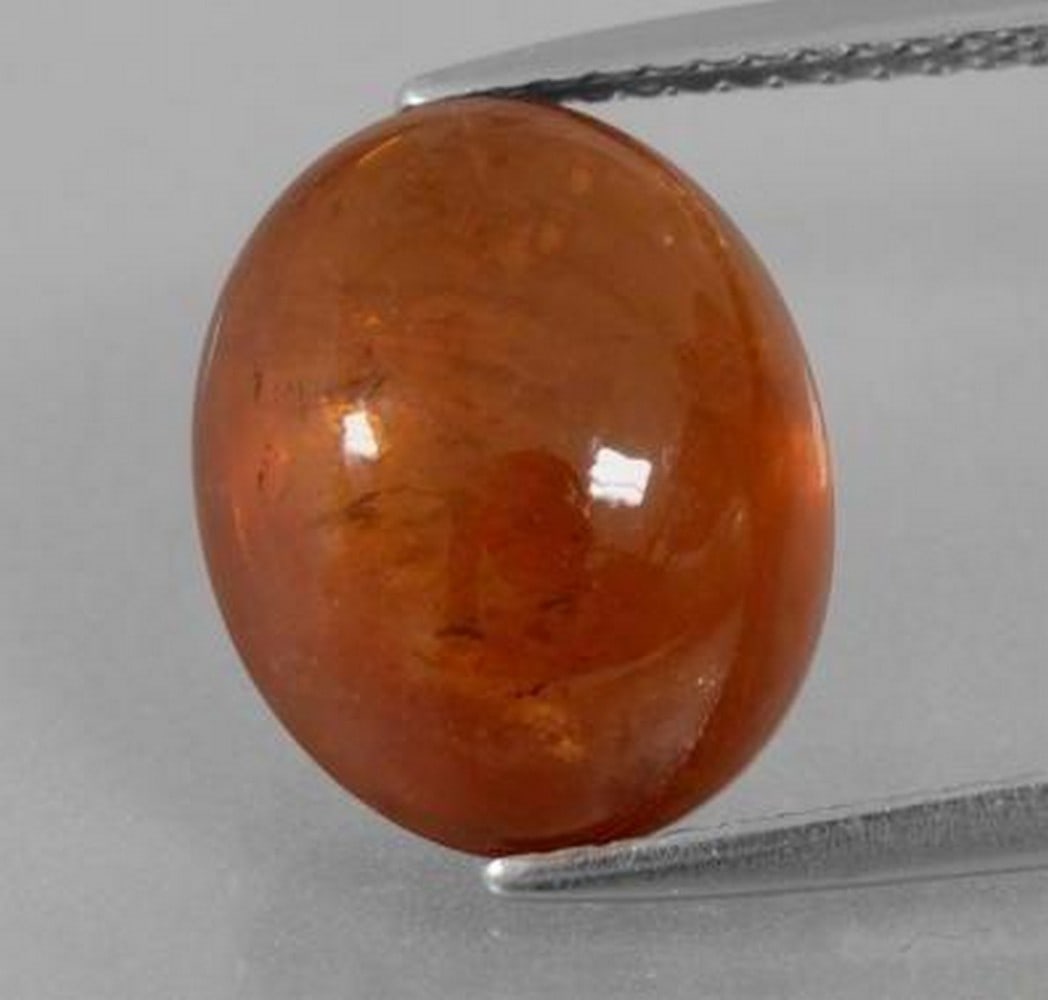 9.5ct Oval Cabochon Vermillion Warm Orange Spessartite Garnet Gemstone: 9.5ct Oval Cabochon Vermillion Warm Orange Spessartite Garnet Gemstone Introducing a radiant gemstone that captures the warmth of the sun: the 9.5ct Oval Cabochon Vermillion Warm Orange